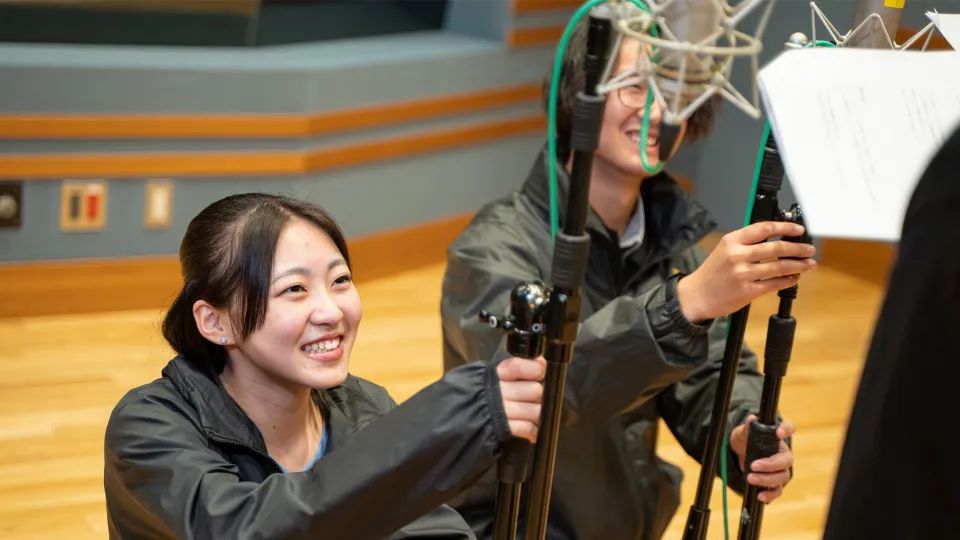 声優の声を集音マイクを使って録音する学生する2人