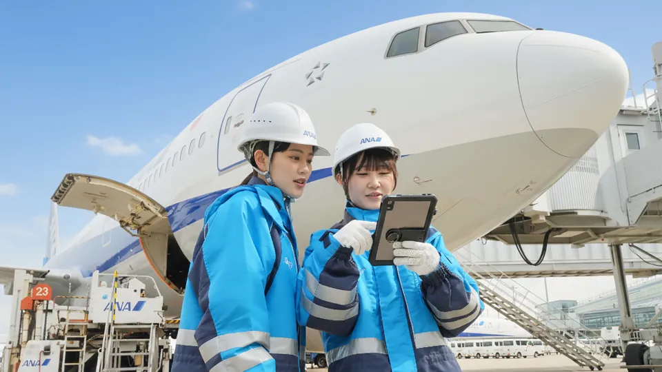 空港の航空機前でタブレットを追加って作業する2人の空港スタッフ