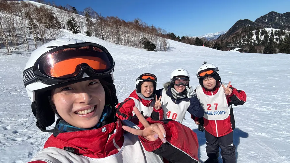 スノーボードの途中、ゲレンデで自撮りする4人の学生