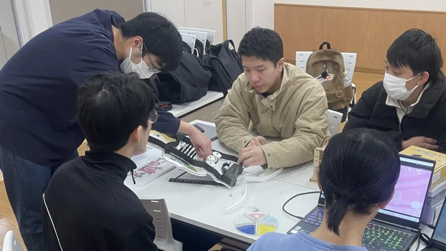 キッズ向け料理体験ゲーム『テキパキキッチン』の解体と組み立てを体験する学生たち