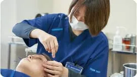 学生が顔に鍼を打っている様子