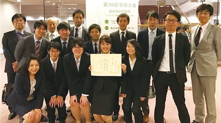 学生たちが賞状を持って記念撮影をしている様子