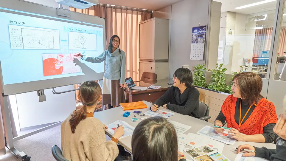 先生たちに絵コンテを説明する学生