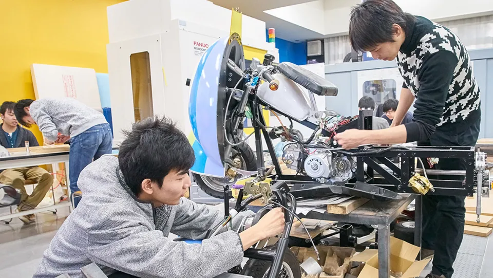 電動自転車を組み立てる2人の学生