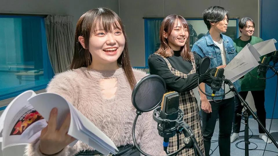 台本を手に楽しそうにアフレコをする4人の学生