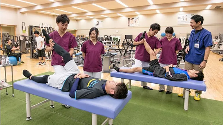 学生たちがストレッチのサポートをしている様子