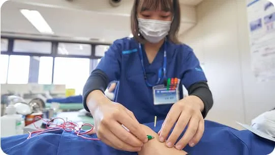 学生が腕に鍼を打っている様子