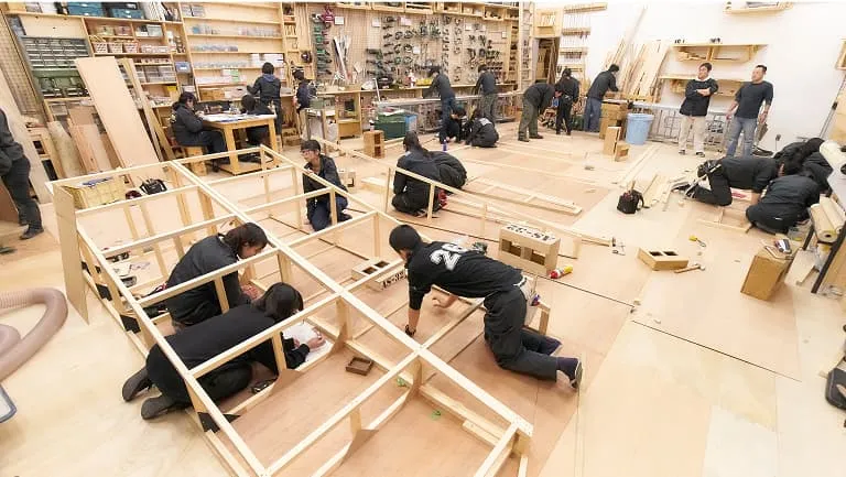 演劇製作室で木材を使ってセットを組み立てる学生たち