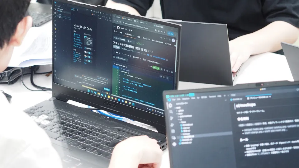 ノートPCでコードを開発する学生たち