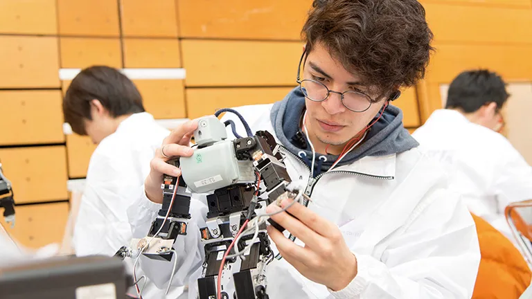 学生が二足歩行ロボットを制作している様子