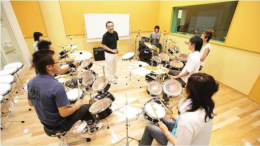 学生たちが講師を囲んで打楽器のレッスンをする様子