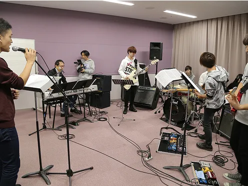 学生たちが講師の前でバンドのレッスンをする様子