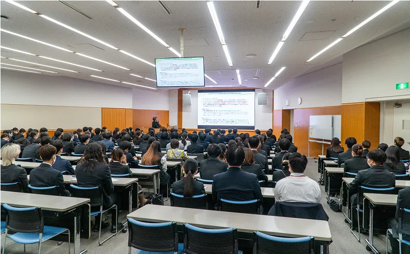 学生たちが講義室でスクリーンを見ながら受講する様子