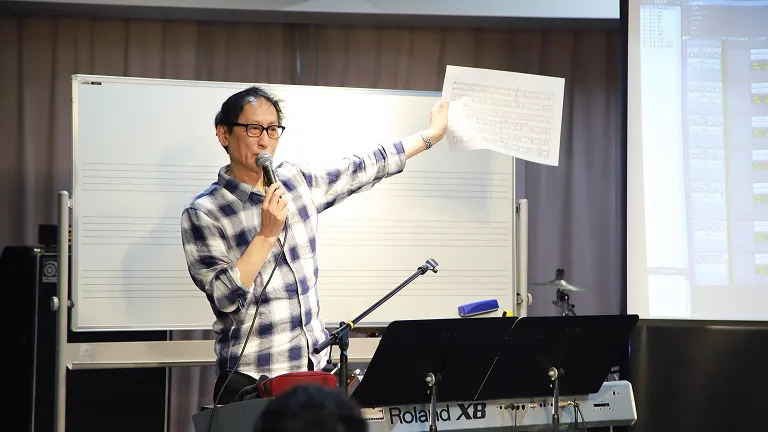 講師がプリントを示しながら授業をする様子