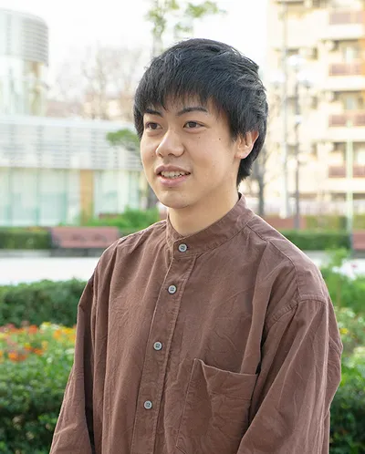 屋外で話している米本 祐大さん