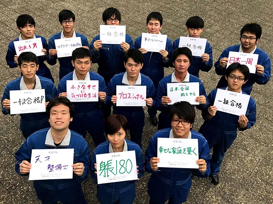 自分の目標が書かれた紙を持って写る大勢の学生たちの集合写真