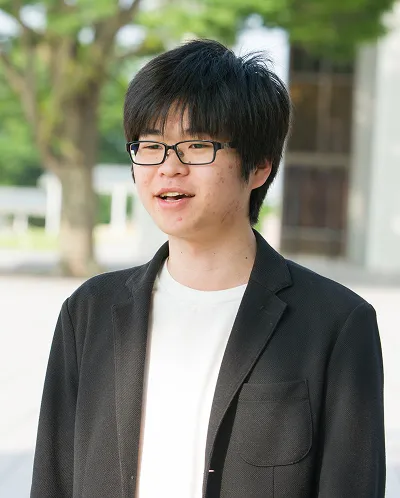 屋外で笑顔で話す小林 悠斗さん