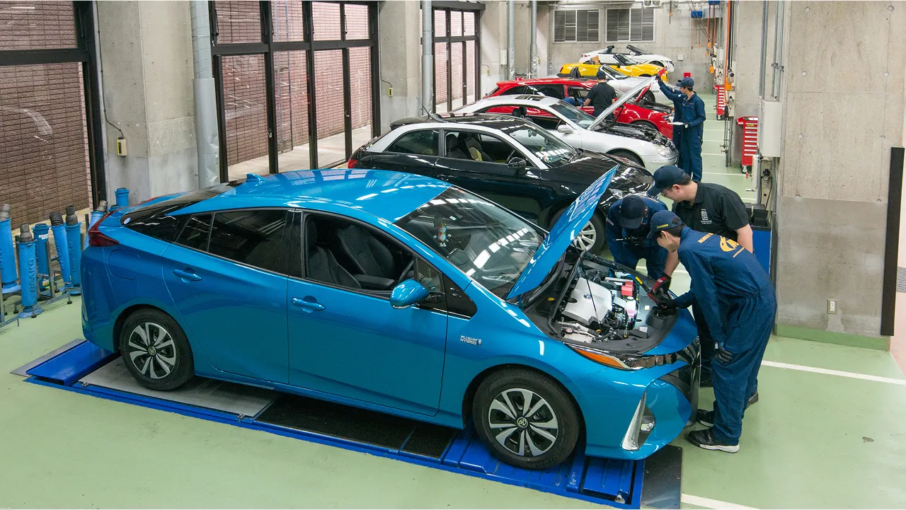 ずらりと並んだ自動車と実習を受ける学生たちの様子