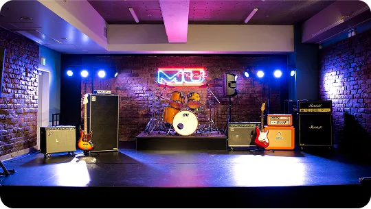 音響機器が完備され照明やネオンサインに照らされたステージ