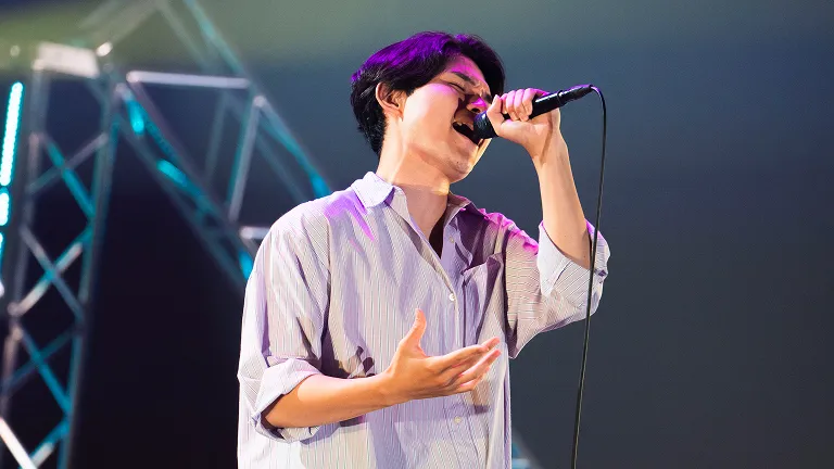 学生が照明に照らされたステージでライブパフォーマンスをする様子