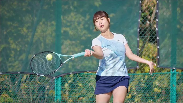 学生がラケットでボールを打ち返している様子