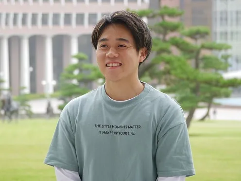 屋外で笑顔で話す天野 拓哉さん