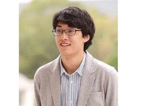 屋外で笑顔で話す塚本 大瑛さん