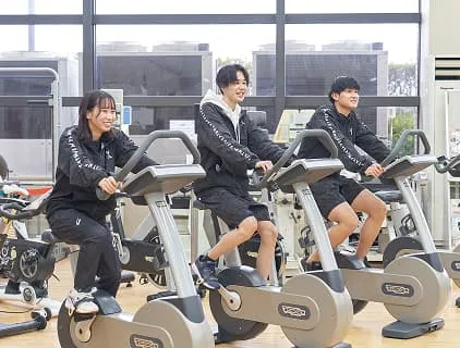 トレーニングマシンを使用している3人の学生の様子