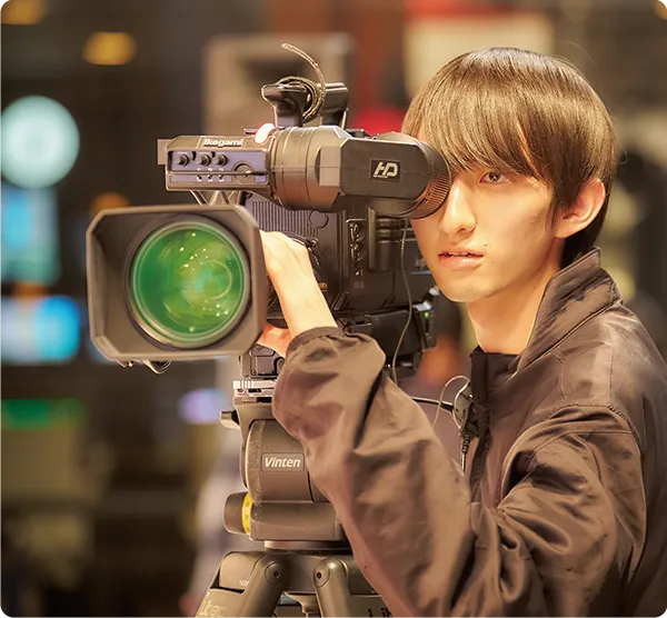 スタジオで業務用テレビカメラを操作する学生