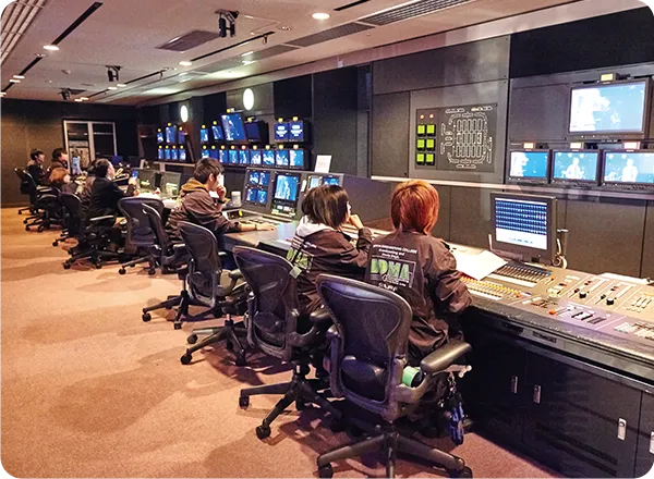 複数の学生がテレビスタジオの機材を操作している様子