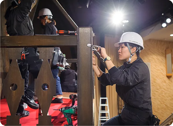 舞台セットを工具で組み立てる学生達