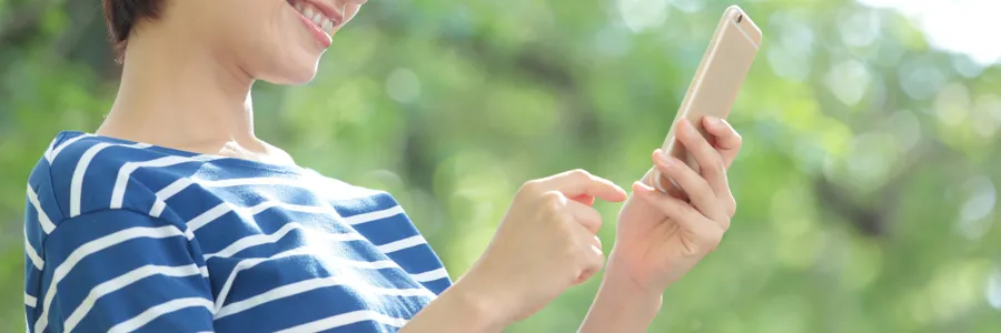 家の外でスマートフォンを操作するイメージ画像