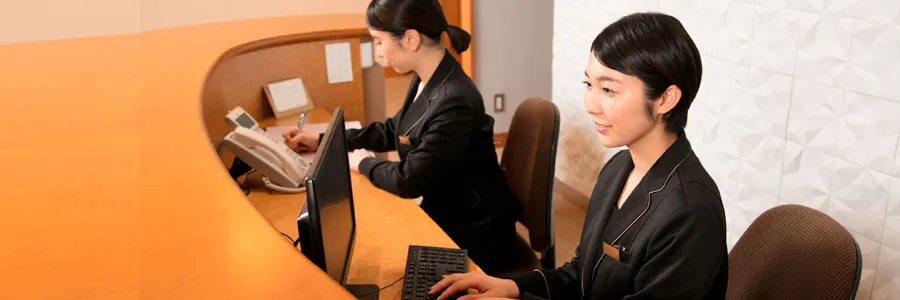 レセプション担当がPCを操作しているイメージ画像