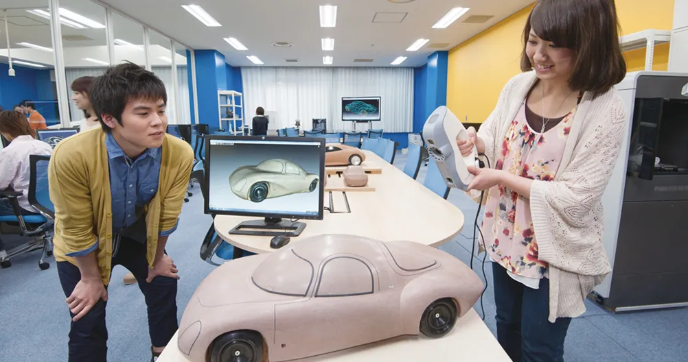 ハンディ型の専用入力装置で模型をスキャンしている様子