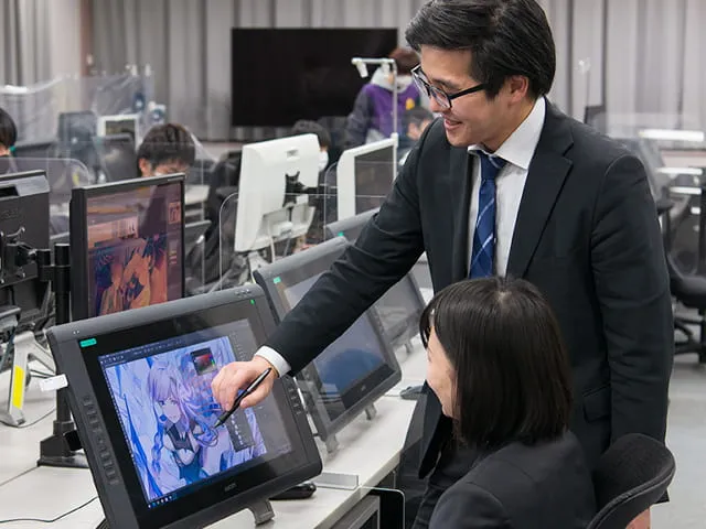 大型液晶タブレットの画面で制作中のイラストについて指導が行われている様子