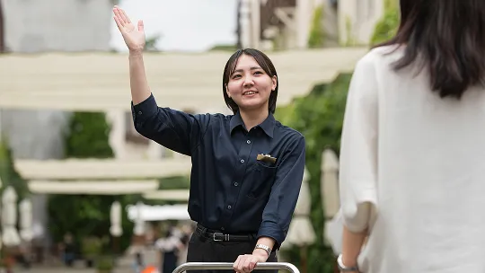 別の制服を着てカートを押す宮崎さん