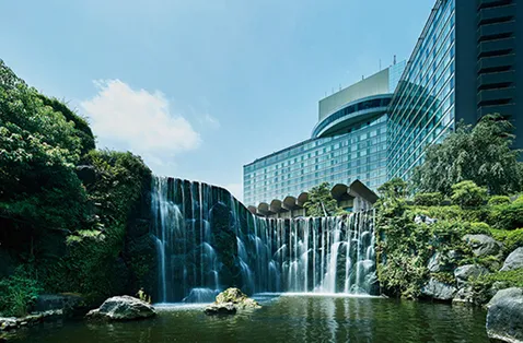 庭園の滝越しに見上げるホテルニューオータニの建物
