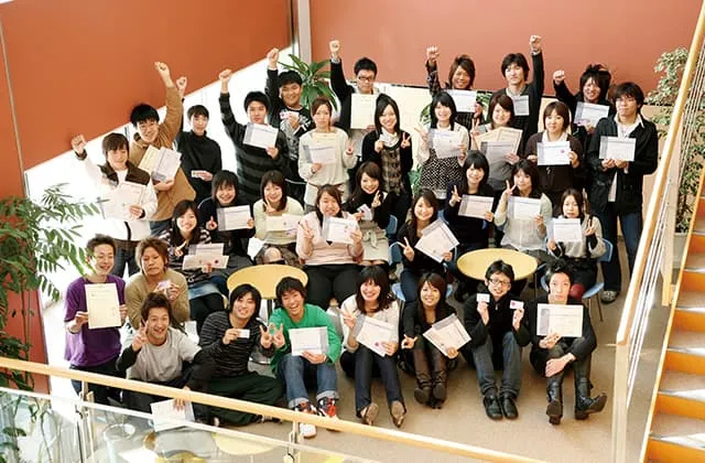 資格試験に合格した生徒達が集まり、証書を持って記念撮影