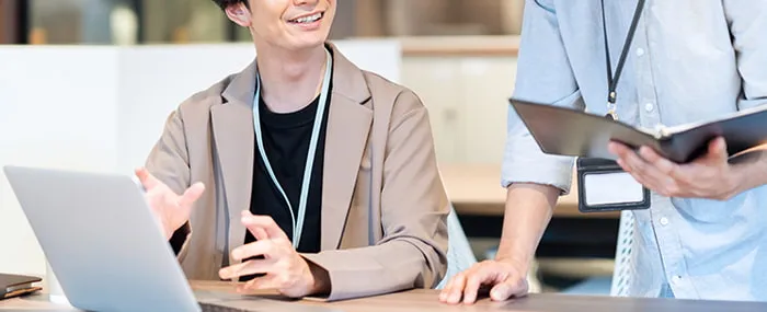 同僚と相談しているSEのイメージ画像