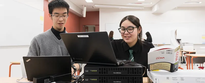 技術書を見ながら開発中の生徒達