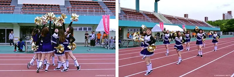 左に円形に集まって金色のポンポンを掲げる演技、右に2列のラインを作っての演技