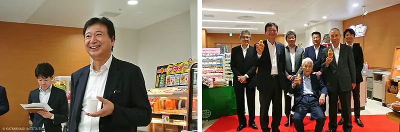 左にお茶の紙コップをもってリラックスした様子の理事長、右にパンを持って並んだ記念写真