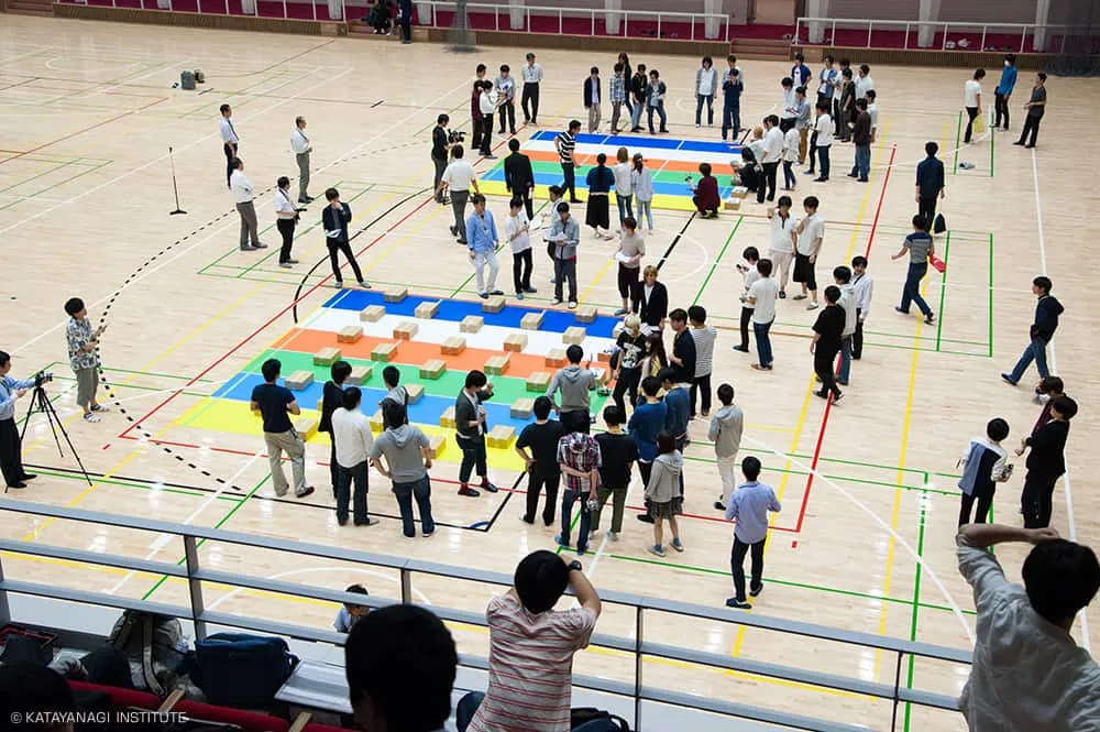 コースごとに色を変え、障害物を設置したスペースと障害物がないスペースが設営された競技中のアリーナを2階観客席が撮影した写真