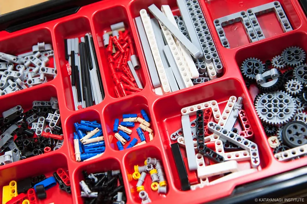 赤い仕分けパレットに収められた色も形も違い、歯車の種類も豊富なパーツ