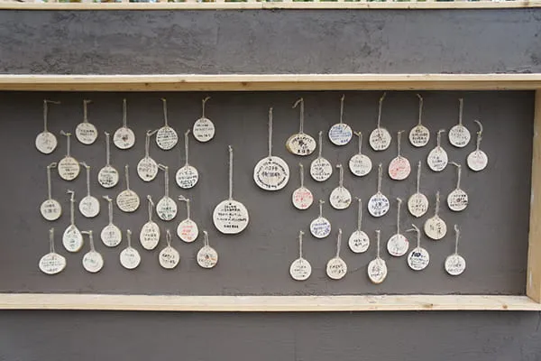 壁に絵馬のように展示された、木のメッセージプレートたち