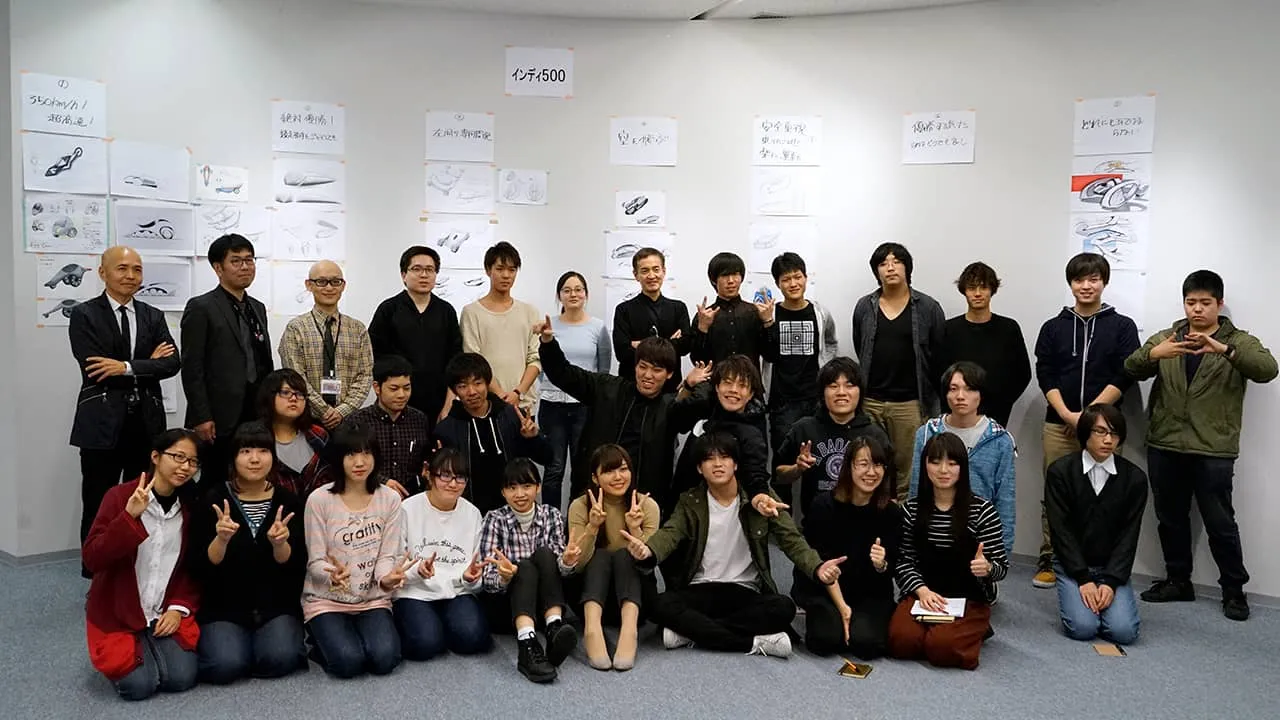 作成した学生たちのデザインを張った壁の前に集まり、特別授業関係者と学生達で記念撮影