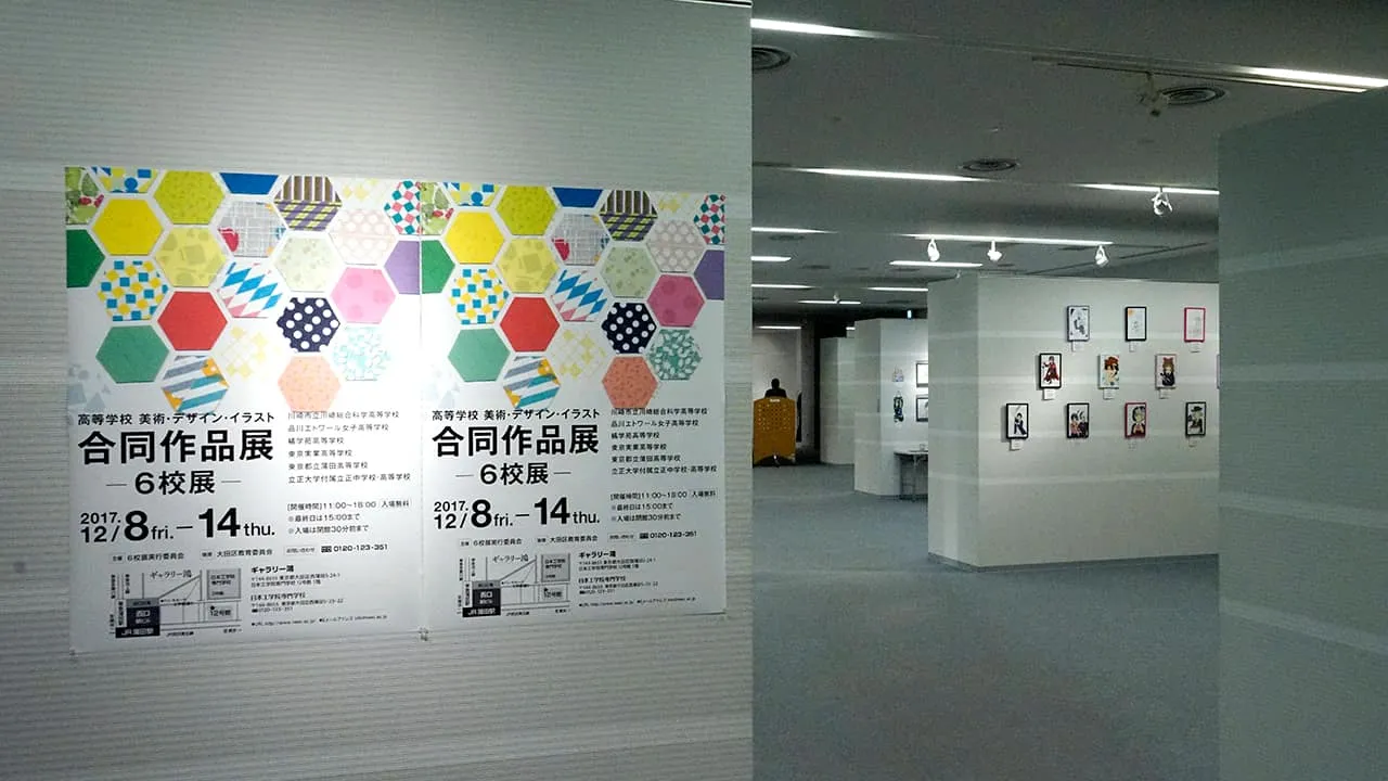 左手前の壁に合同作品展6校展のポスター、右奥に作品を展示た壁が並んでいる様子
