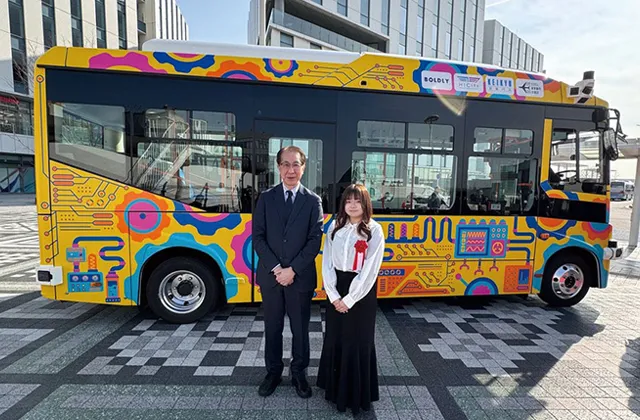 ラッピングが施されたバスと受賞の記念撮影