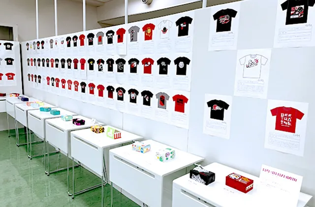 様々なTシャツデザインとグッズの展示
