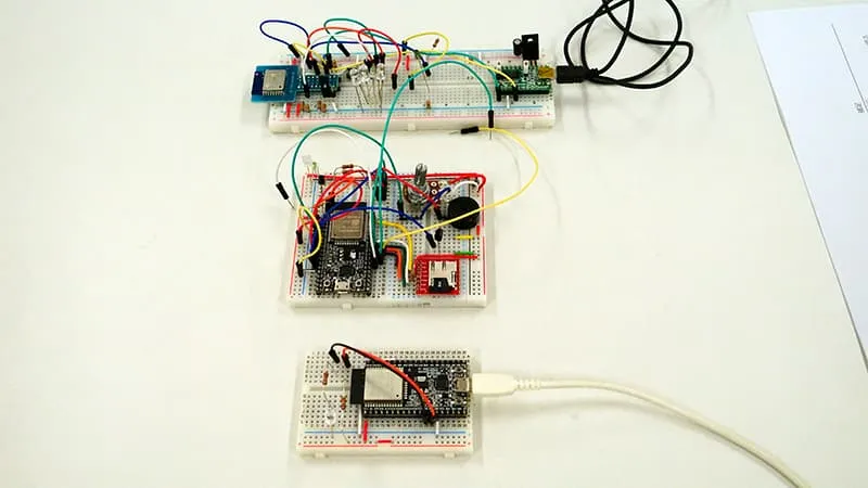 組み立てられた3つの基板を縦に並べた写真。上の基板には黒の端子が外部接続され、真ん中は外部接続なし、下の基板には白の端子が外部接続されている